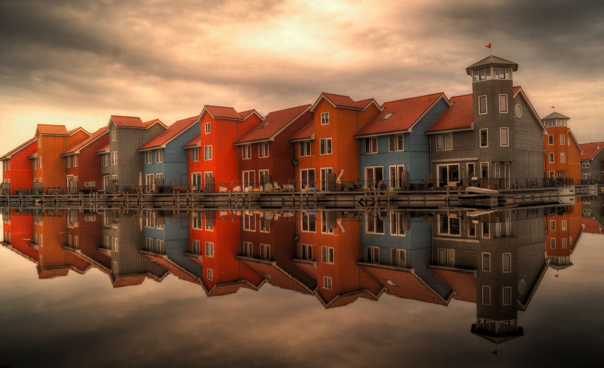 A row of colorful houses are reflected in the water.