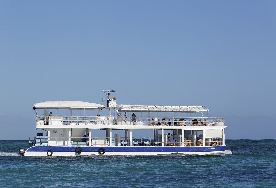 A blue and white boat is floating on top of a body of water.