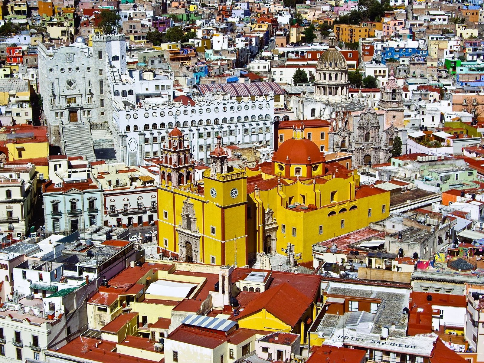 An aerial view of a city with a yellow building in the middle.