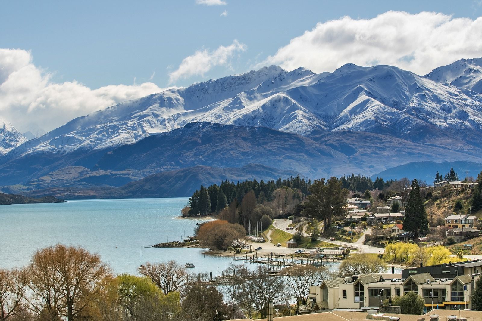 A lake with mountains in the background and houses in the foreground