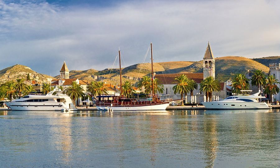 A few boats are docked in a harbor with mountains in the background