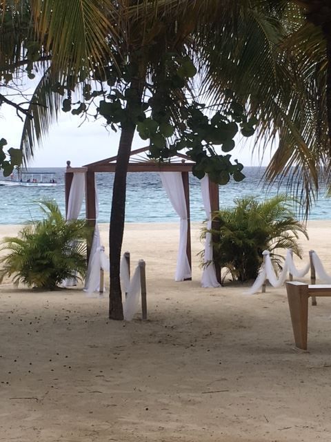 A beach with a gazebo and chairs in the sand