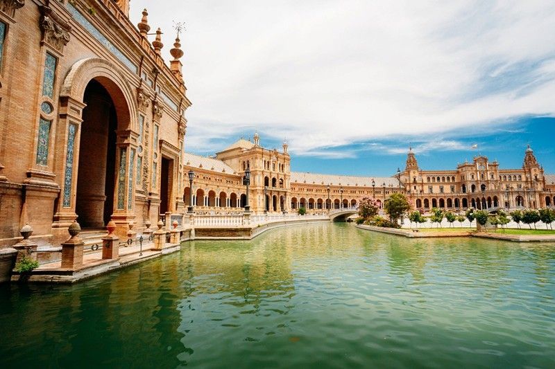 A large building with a pond in front of it.