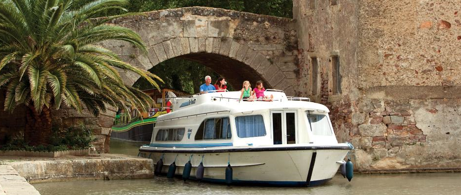 A boat is going under a bridge on a river.