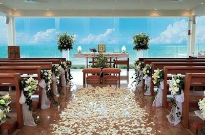 A church decorated for a wedding with a view of the ocean.
