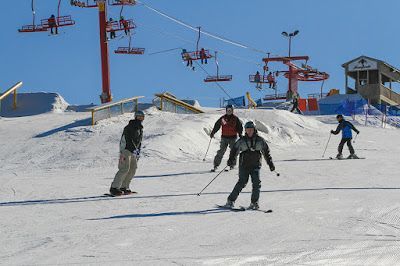 A group of people are skiing down a snow covered slope.