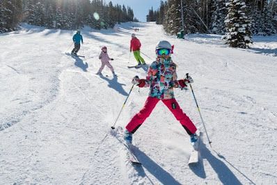 A group of people are skiing down a snow covered slope.