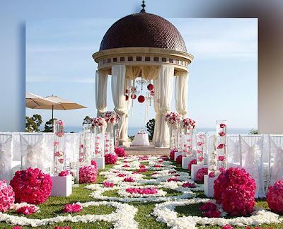 A gazebo is decorated with pink and white flowers