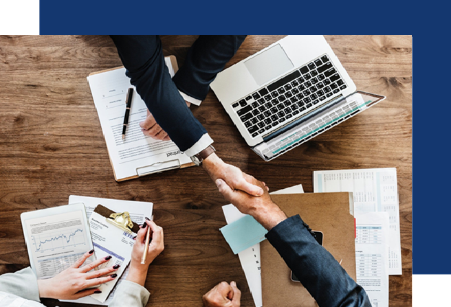 Un grupo de personas se dan la mano sobre una mesa de madera.