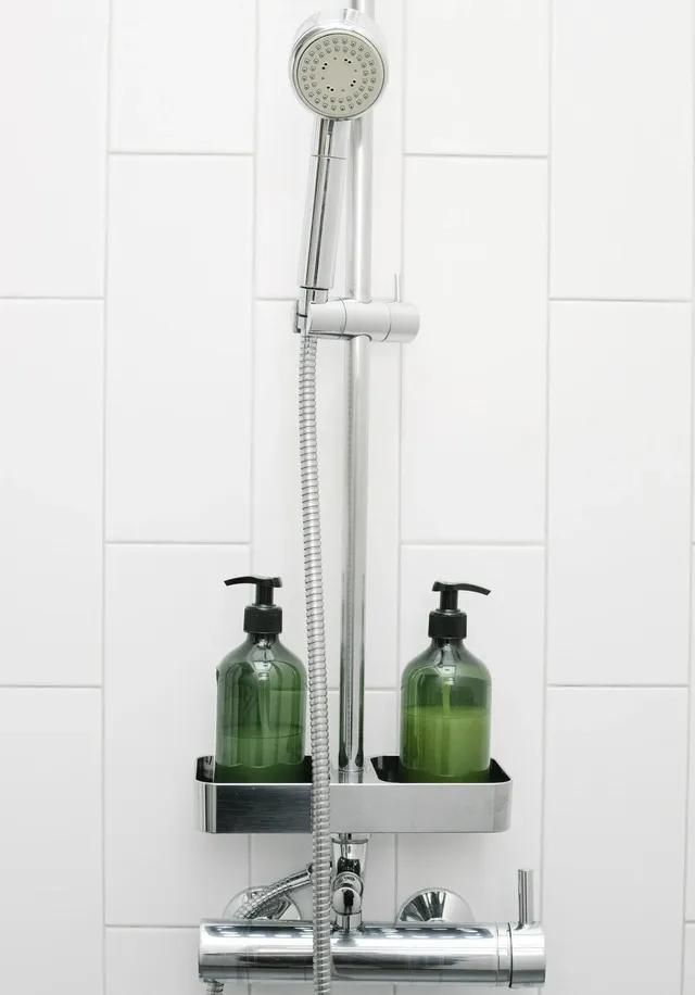 Silver shower head and green bottles