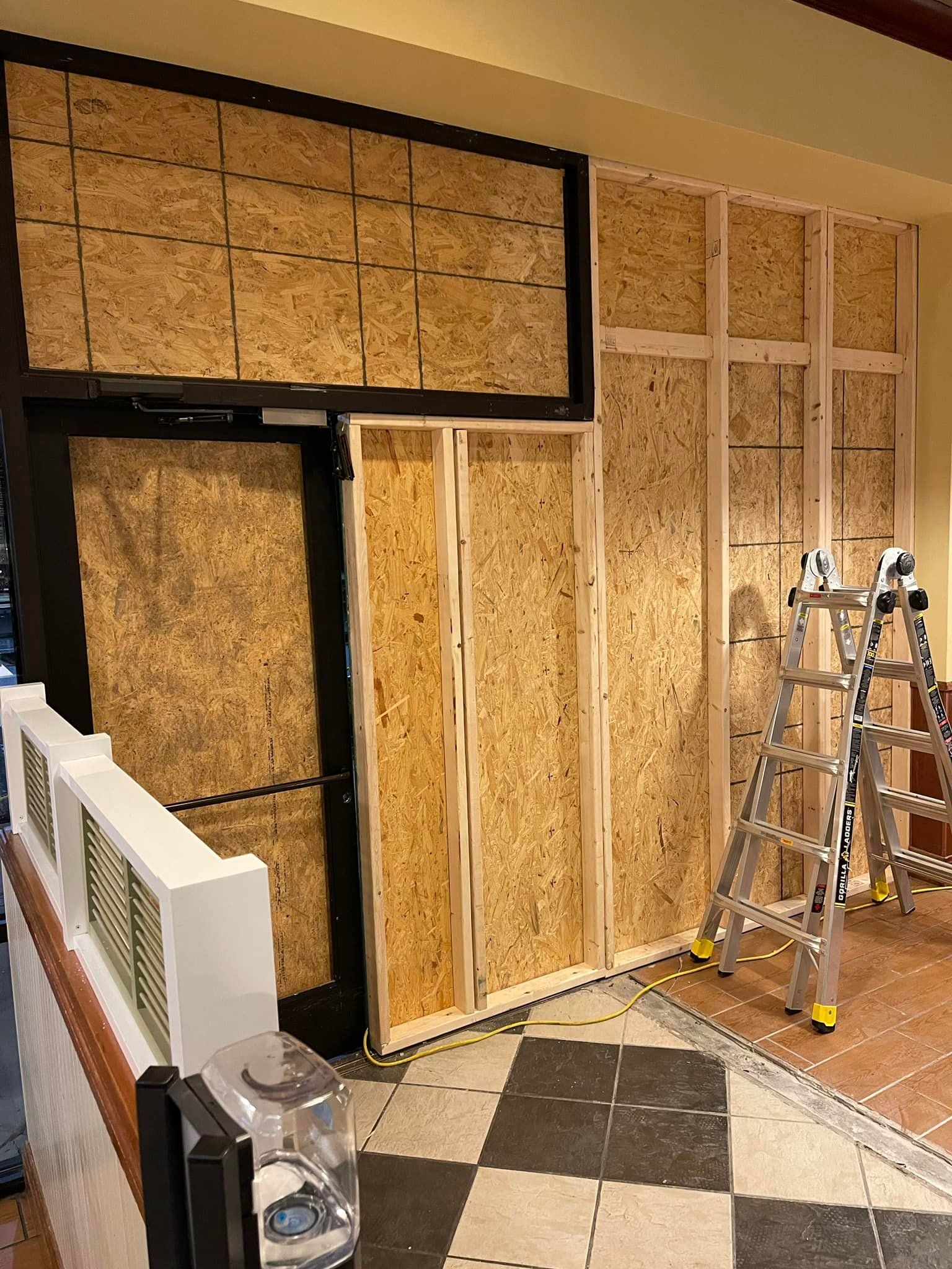 Interior construction: Wood-framed walls partially covered with OSB. A ladder sits nearby.