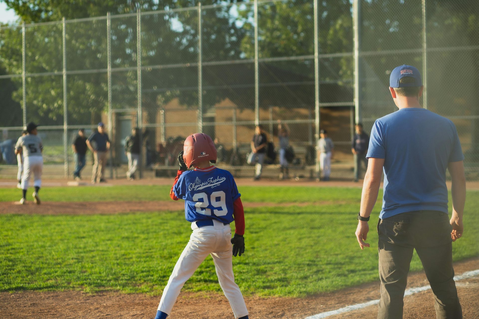 Baseball player sliding into home plate, catcher in front. Blue and gold uniforms, action shot.