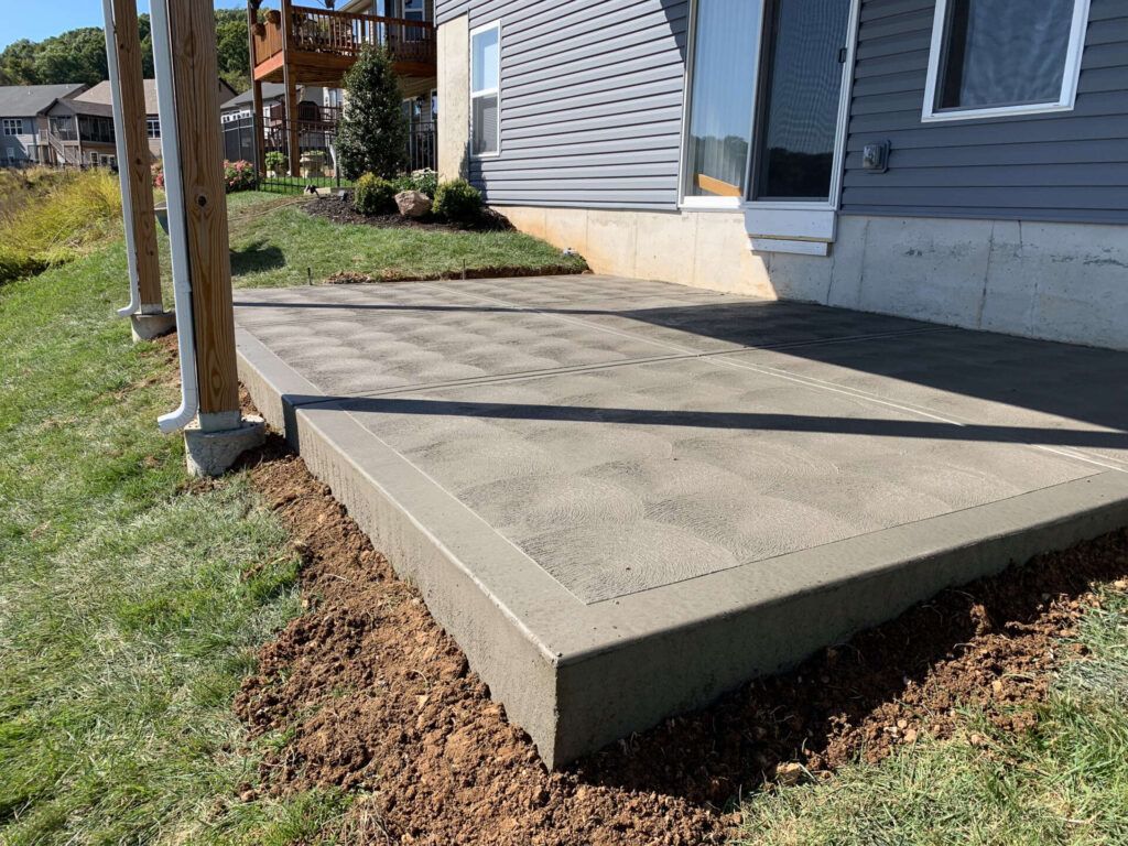 A patio is being built in front of a house.