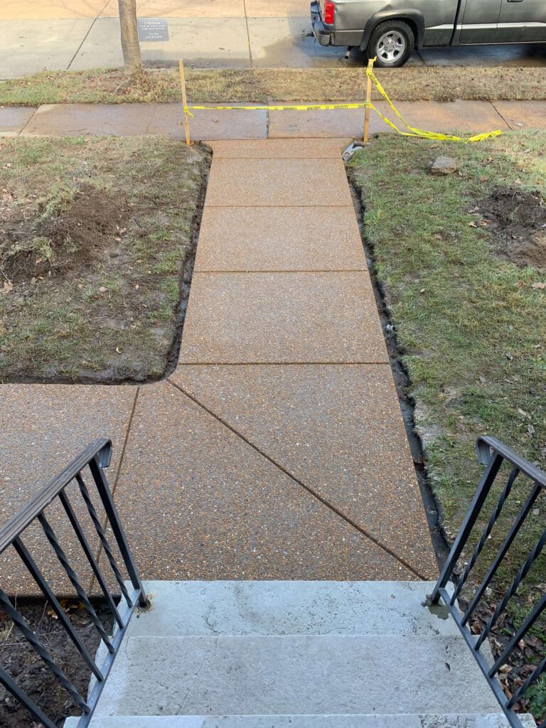 A concrete walkway with stairs and a truck parked on the side of the road.