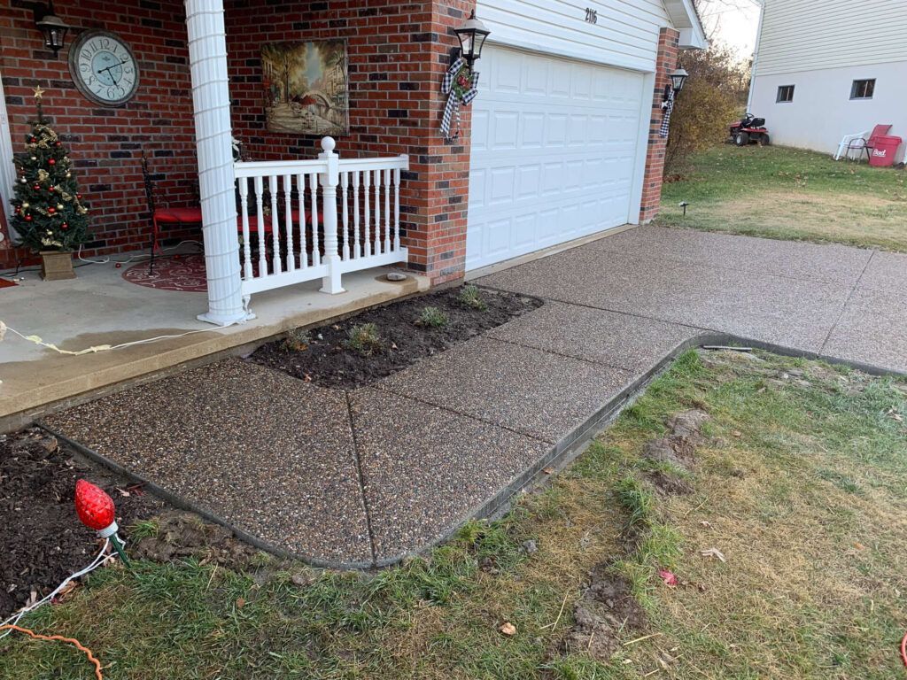 A brick house with a white garage door and a walkway leading to it.