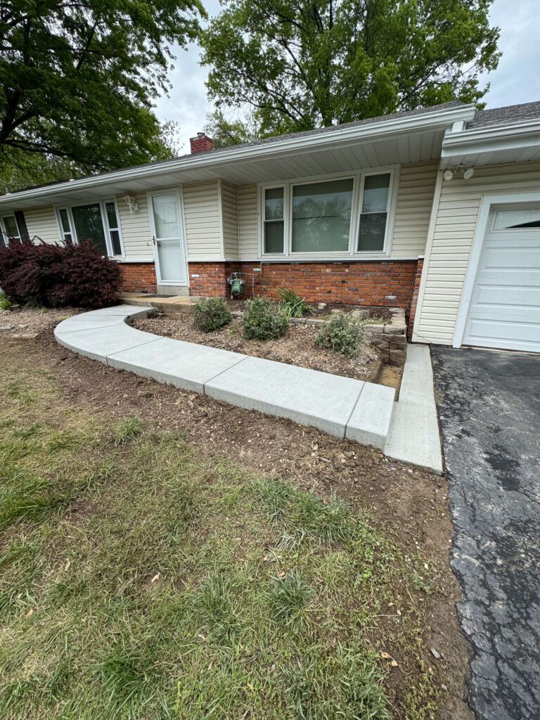A house with a concrete walkway leading to the front door.