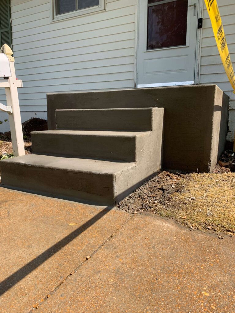 A concrete staircase is being built in front of a house.
