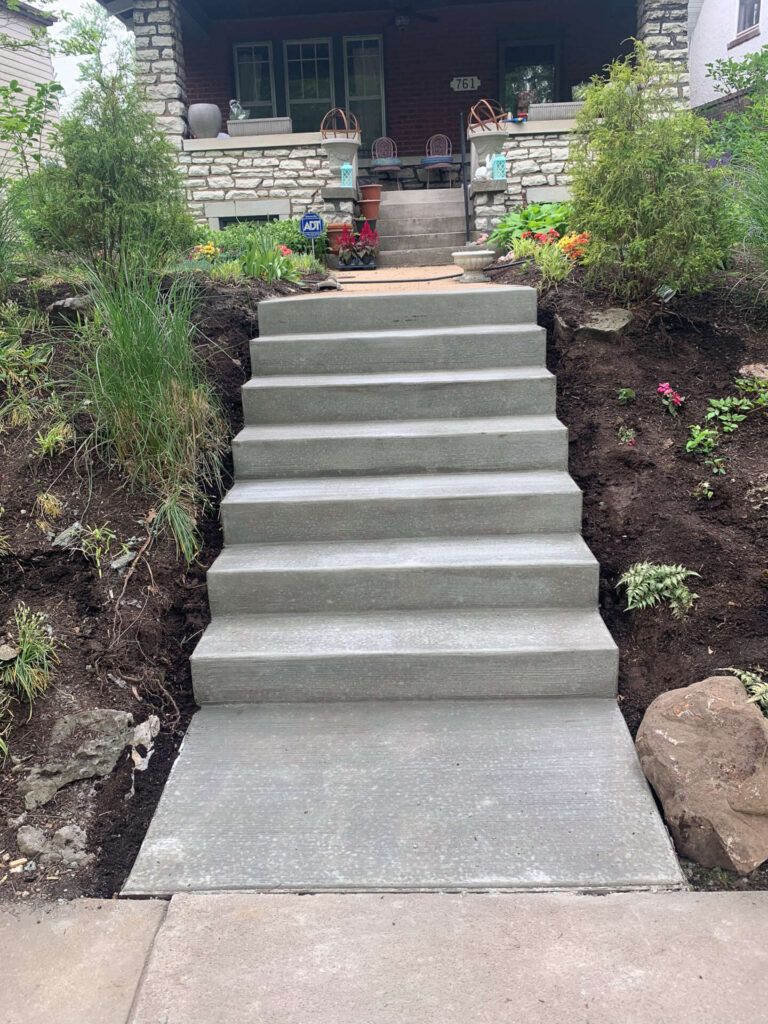 A set of concrete stairs leading up to a house.