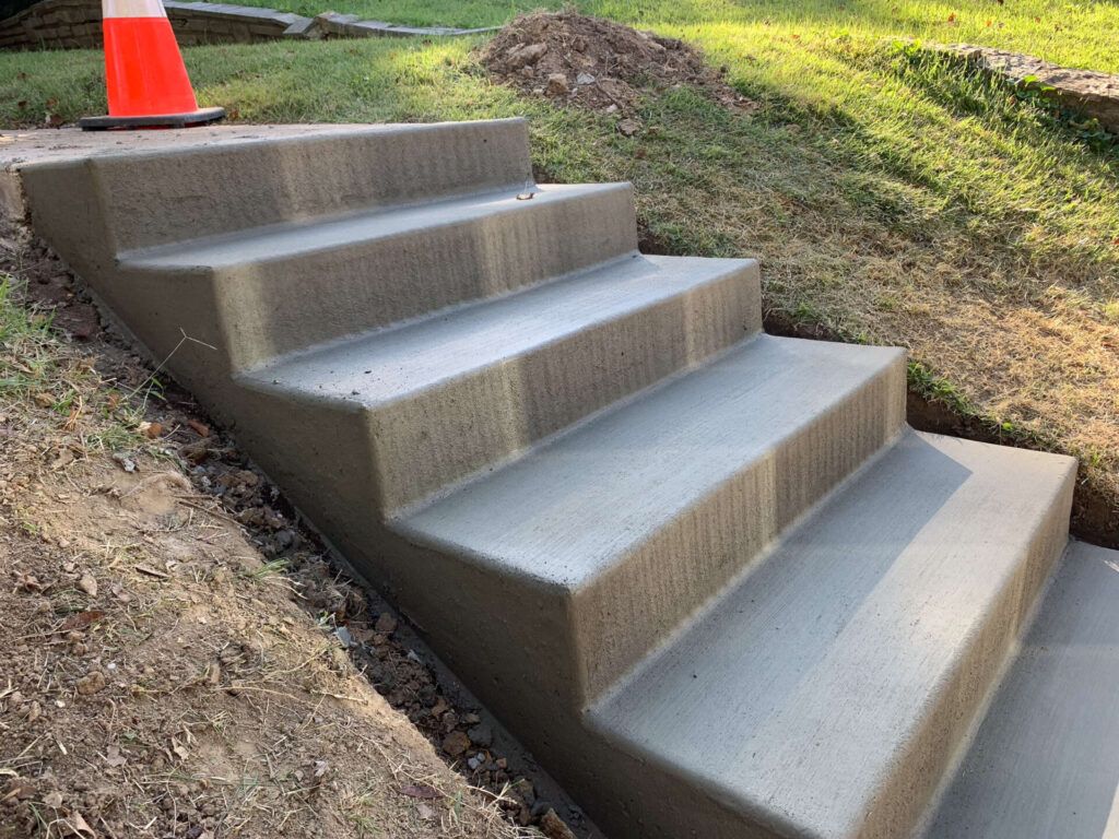 A concrete staircase is being built next to a grassy hill.