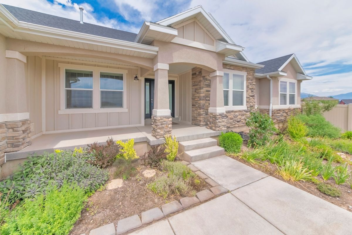The front of a house with a concrete walkway leading to it.