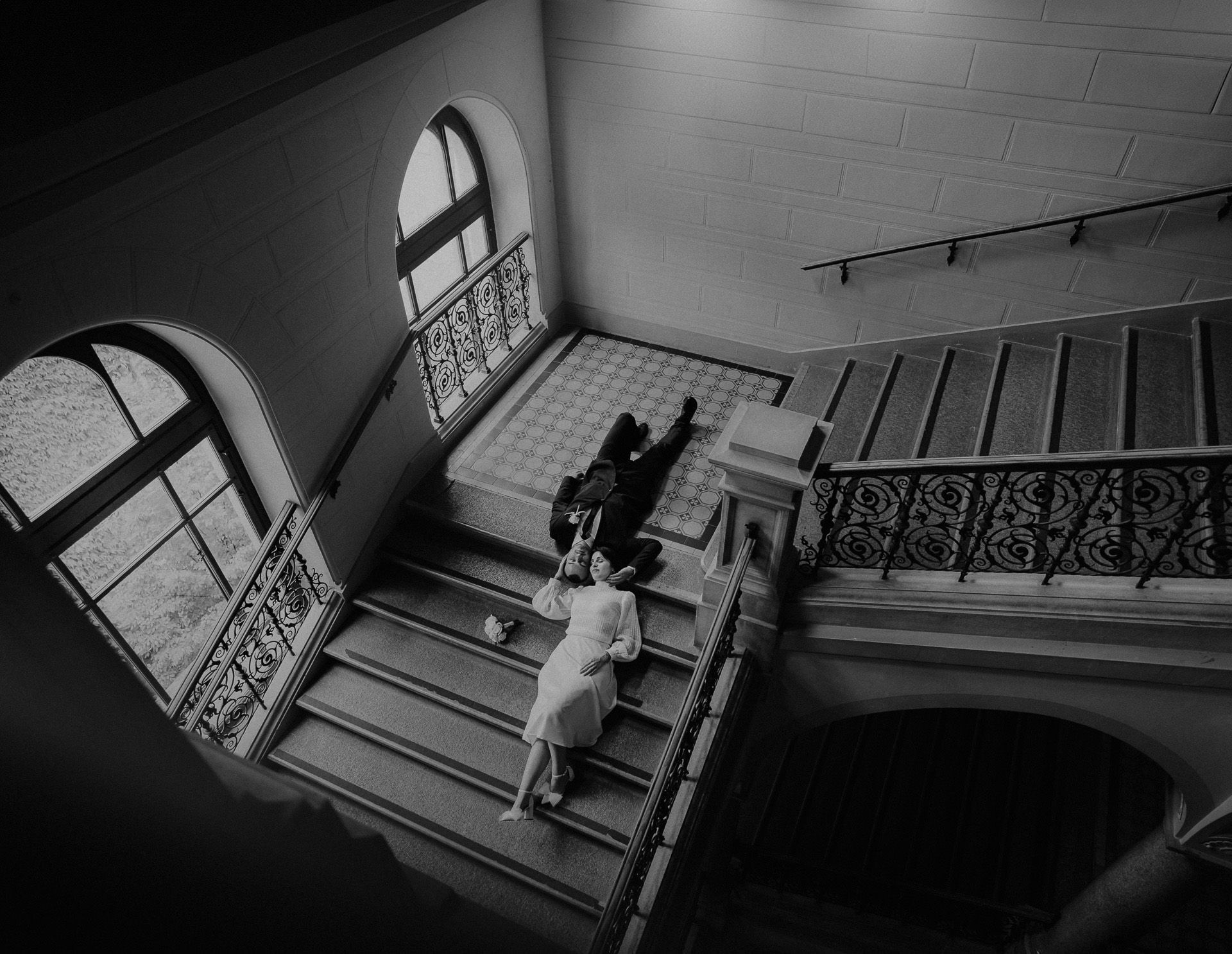 Ein Schwarzweißfoto eines Mannes und einer Frau, die auf einer Treppe sitzen.