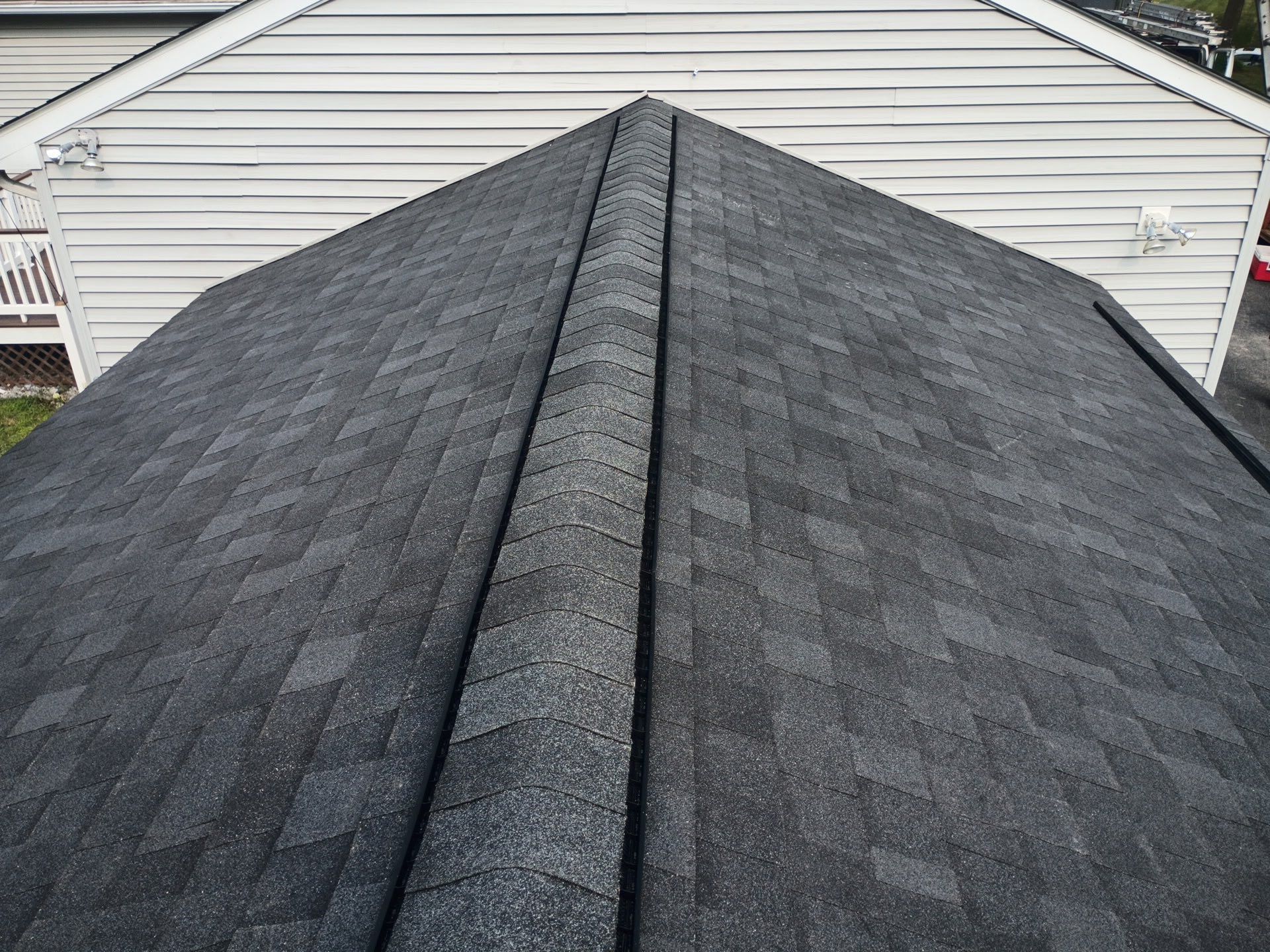Dark gray asphalt shingle roof with a ridge, viewed from above.