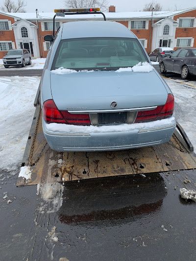 A car is sitting on top of a tow truck in the snow.