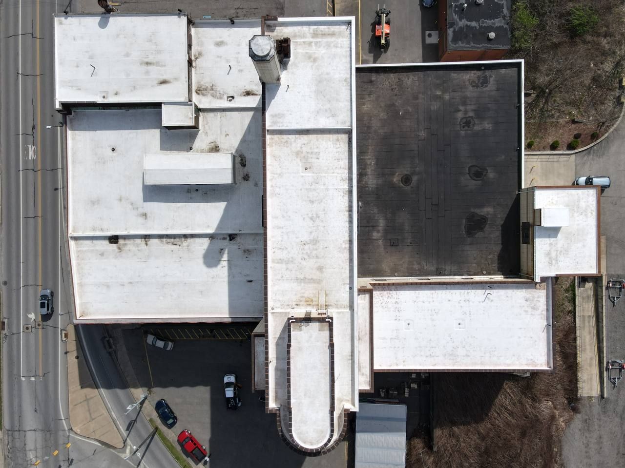 An aerial view of a large building with a white roof