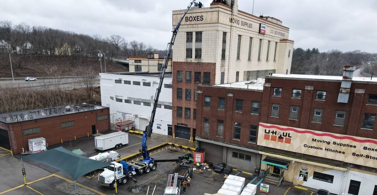 An aerial view of a construction site with a large building in the background