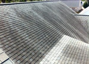 A roof with wind damage to its shingles