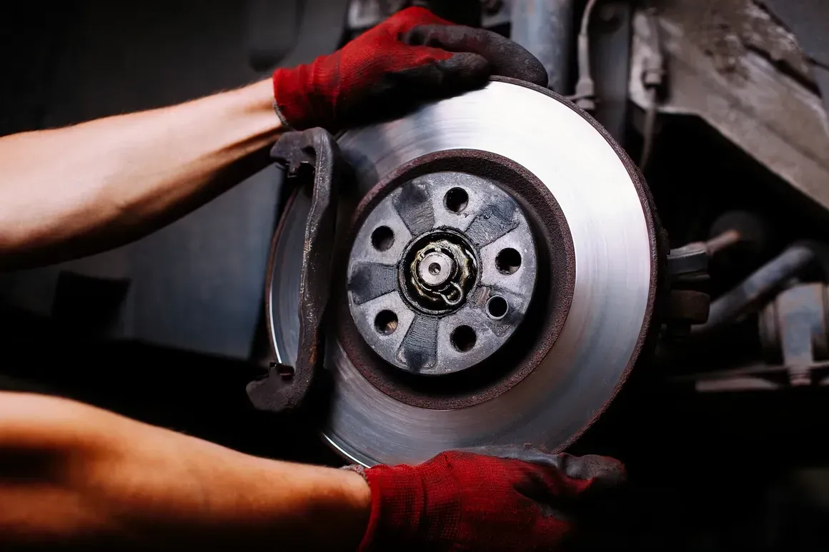 A person is fixing a brake disc on a car.  | Royal Expert Auto Service & Discount Tire Center