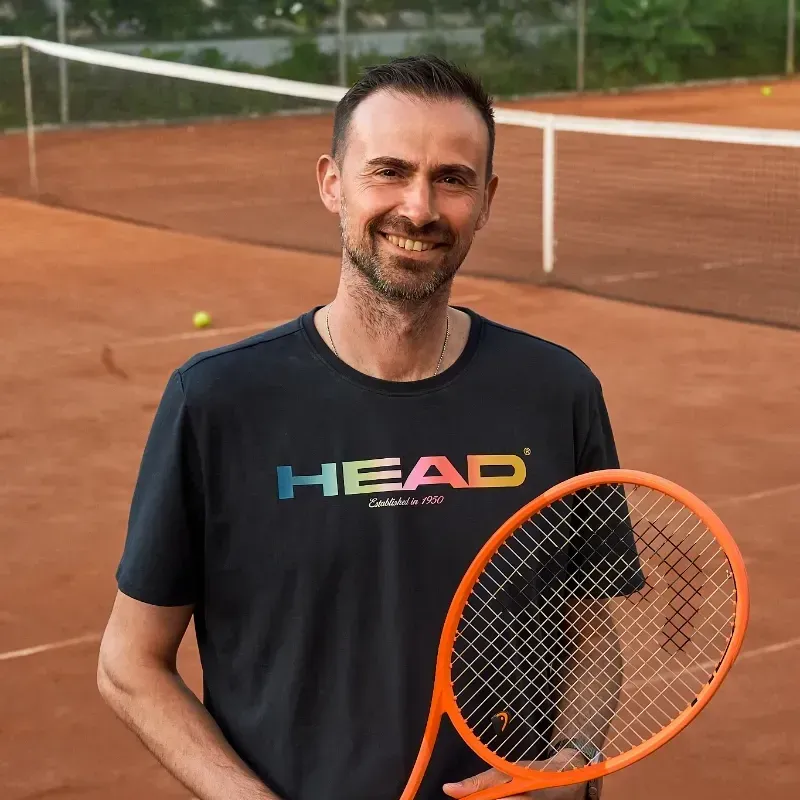 Ein Mann hält einen Tennisschläger auf einem Tennisplatz