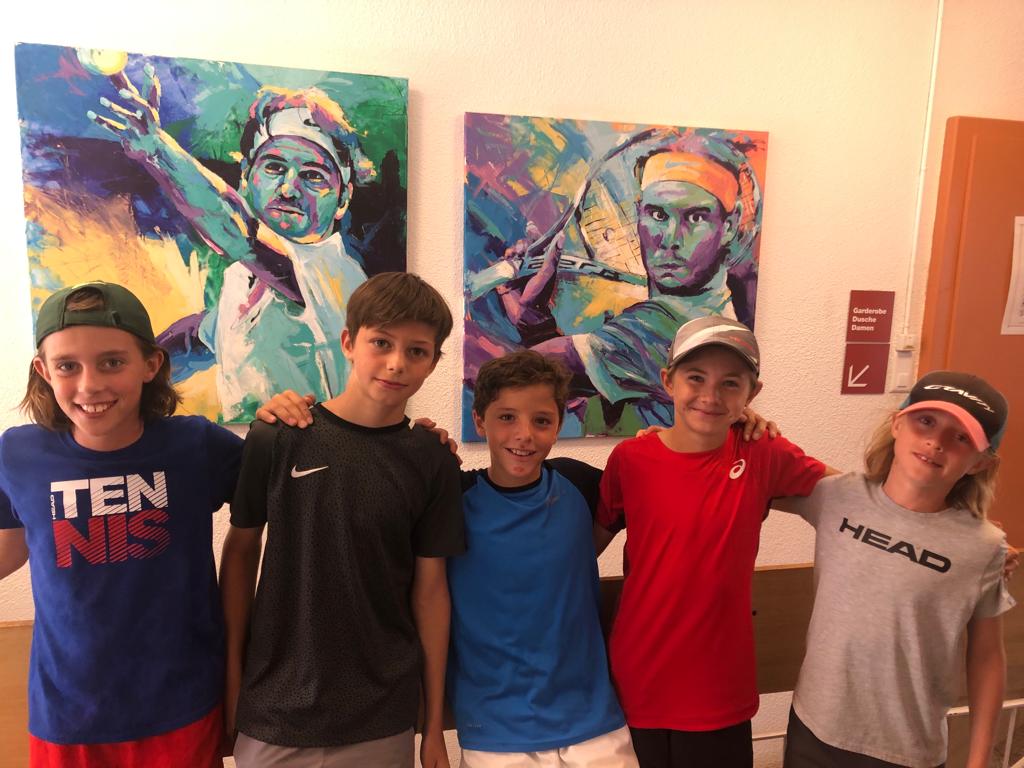 Eine Gruppe junger Jungen posiert vor zwei Gemälden für ein Foto.