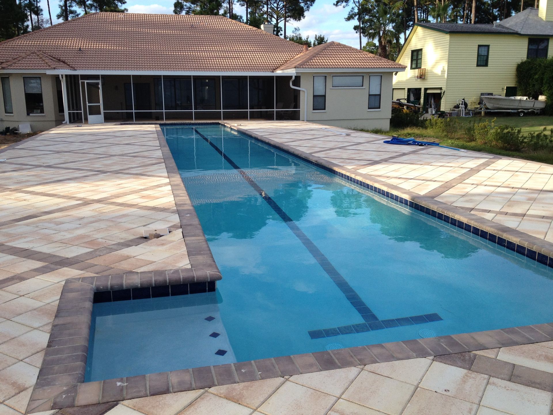 A white roofing company truck is parked in a grassy field.