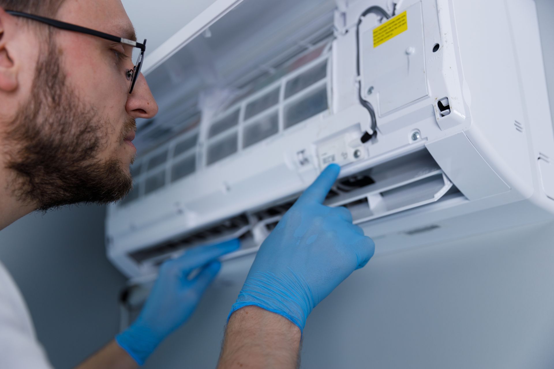 Person attaching gauges to an outdoor air conditioning unit.