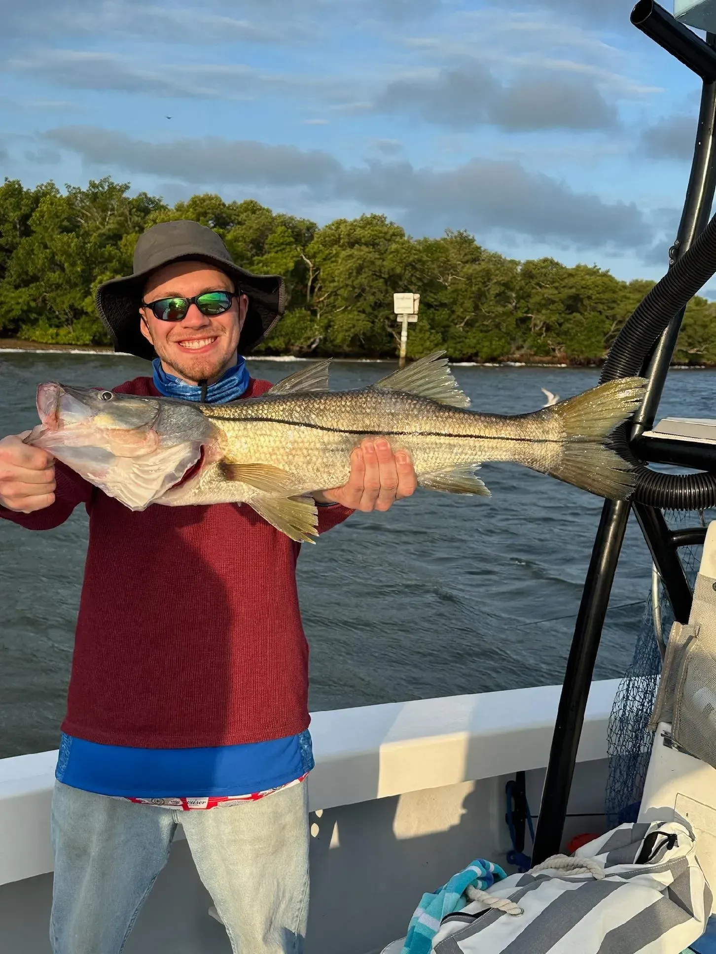 A man is holding a large fish on a boat.