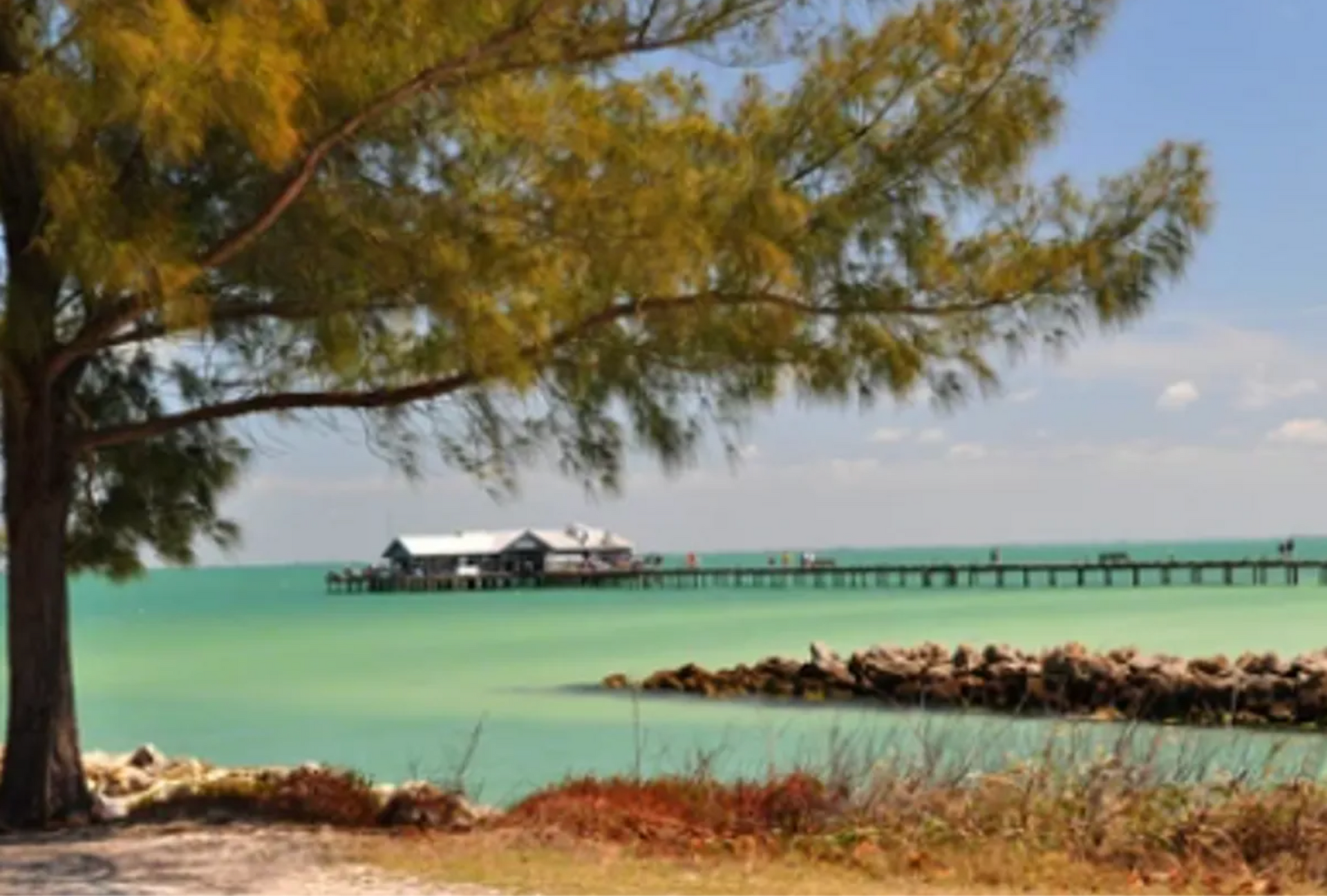 A pier in the ocean with a house on it