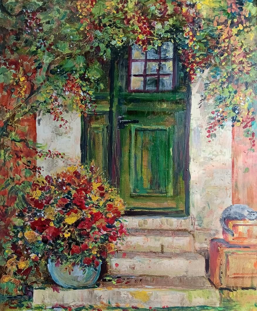 Green door with stone steps and a floral arrangement, surrounded by fall foliage.