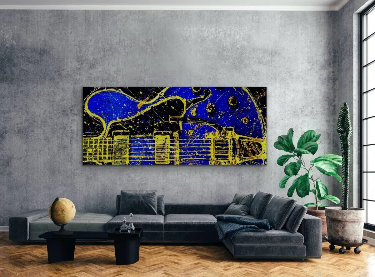 Abstract blue and yellow art above a gray sectional sofa in a modern living room.