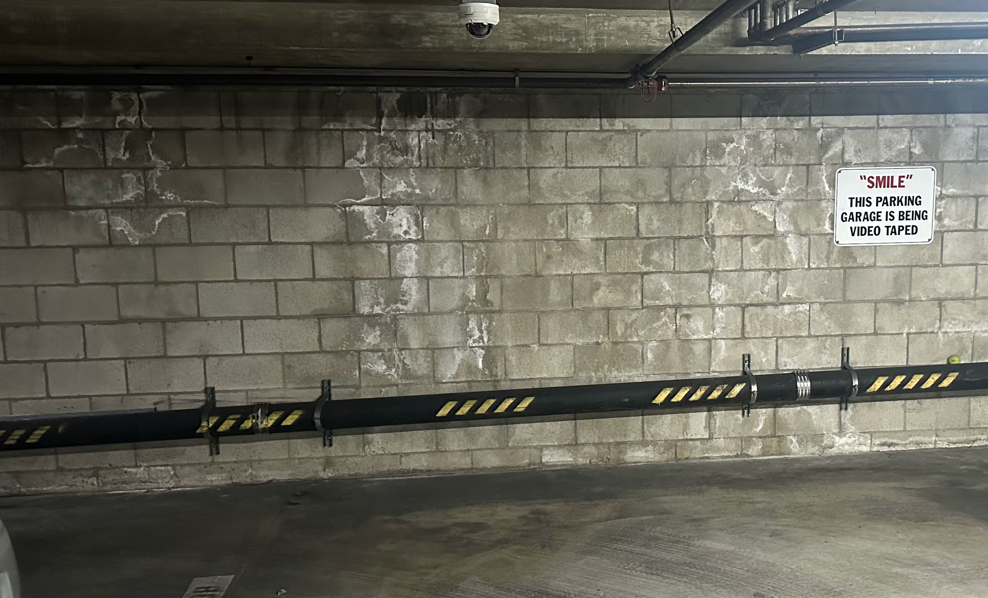 A parking garage with a sign on the wall that says no parking