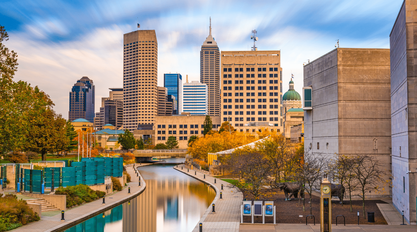 A city skyline with a river in the foreground and buildings in the background.