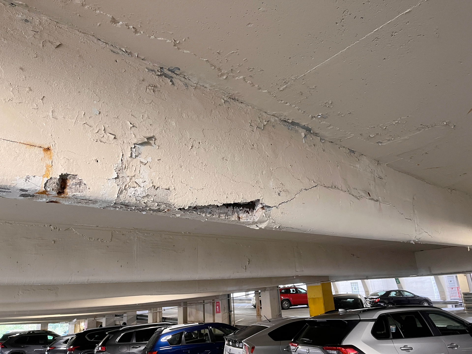 A parking garage with a lot of cars parked underneath it.