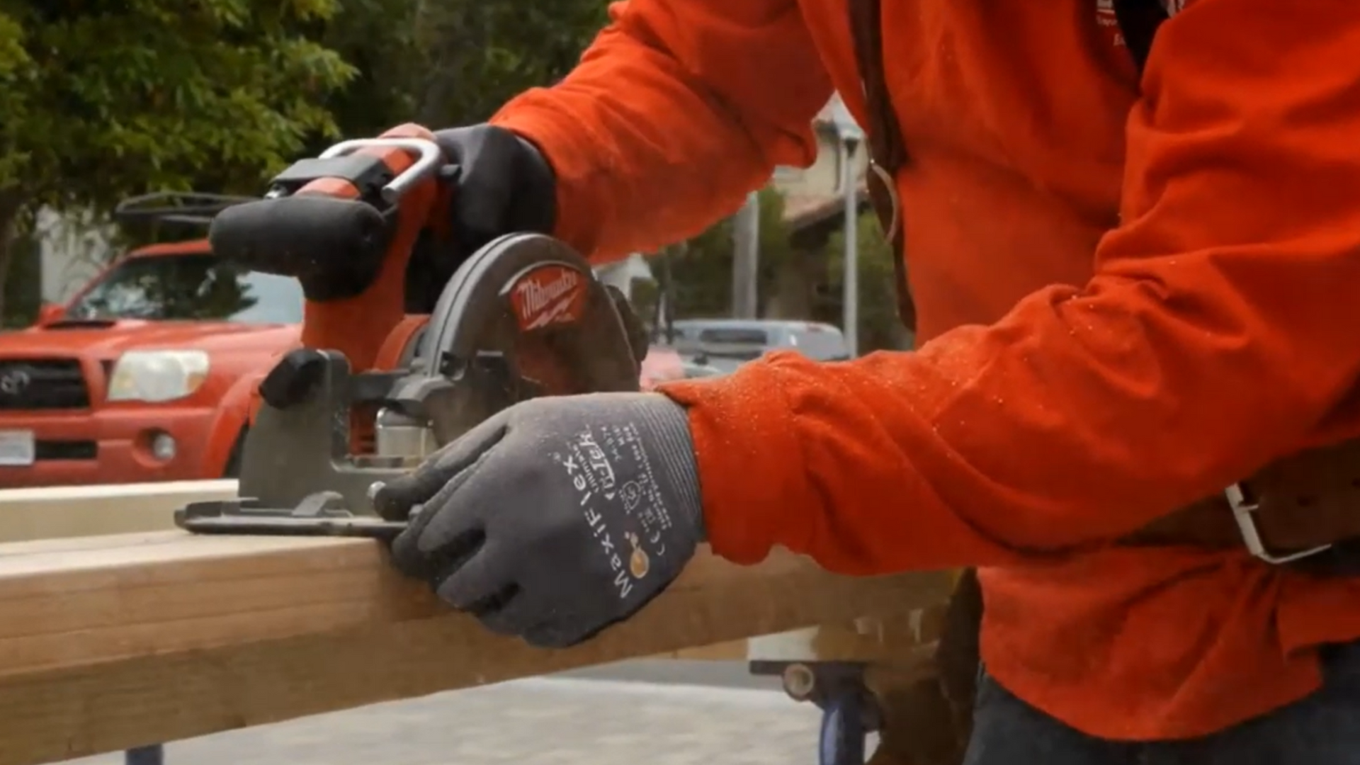 a man is using a circular saw to cut a piece of wood.