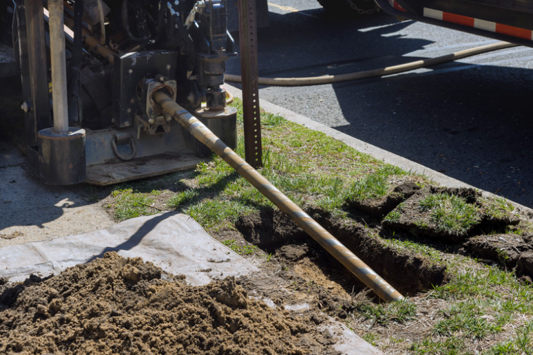 A hose is being used to dig a hole in the ground