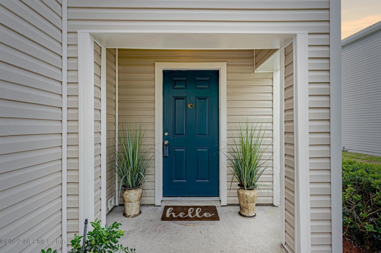a blue door with a hello mat in front of it