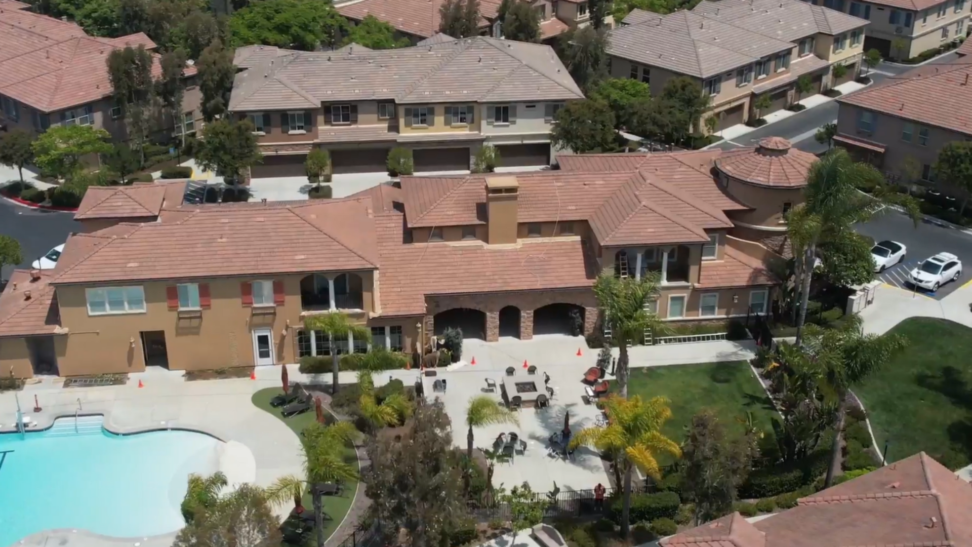 An aerial view of a large house with a pool in front of it.