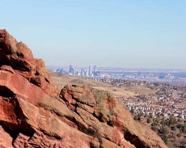 a view of a city from the top of a rocky mountain.