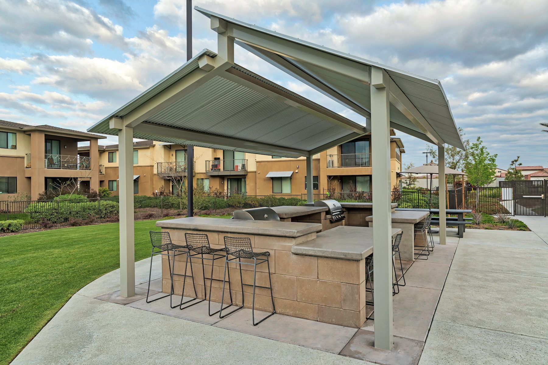 A picnic area with tables and chairs under a canopy.