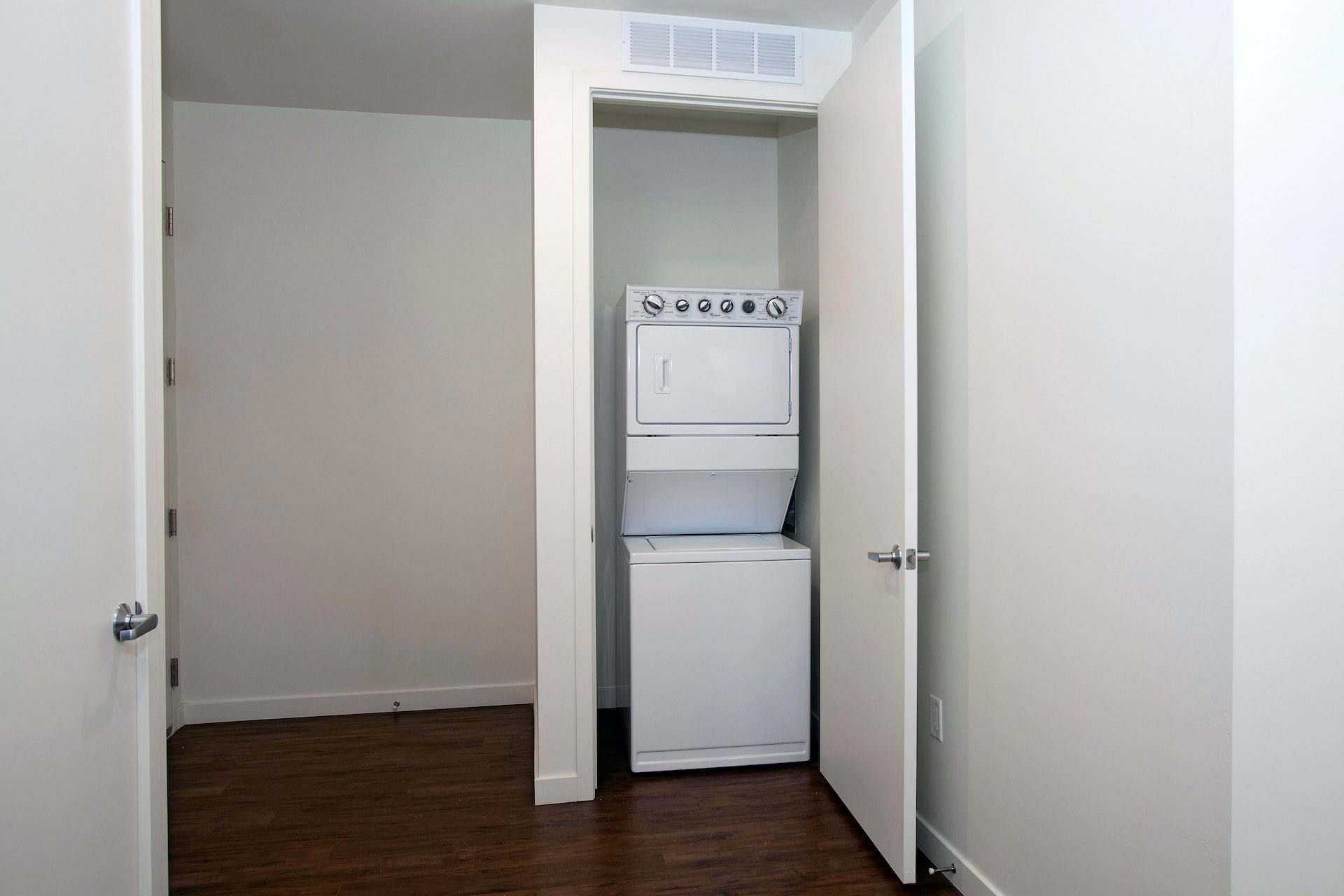 A washer and dryer are stacked on top of each other in a closet.