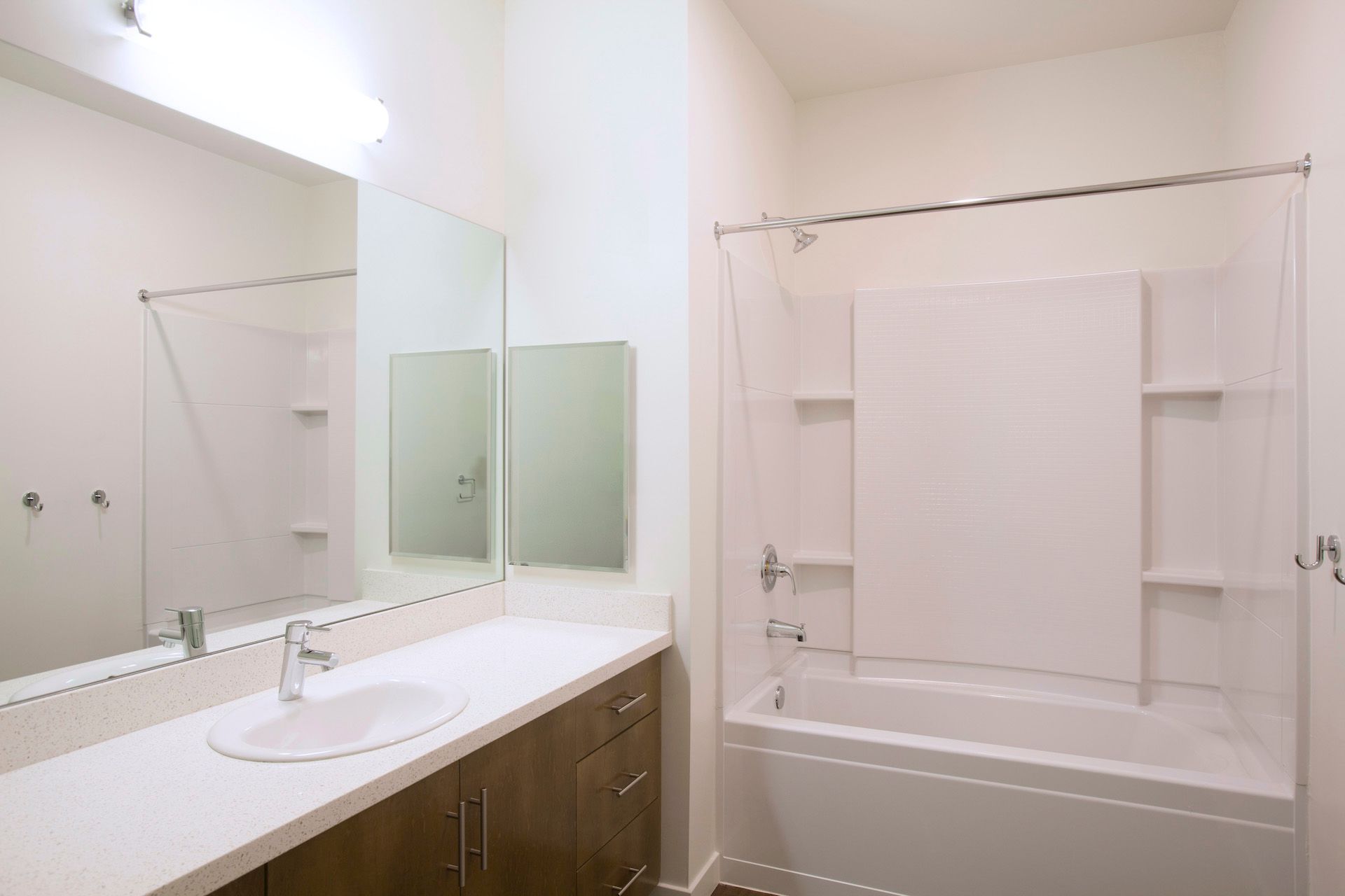A bathroom with a sink , tub , shower and mirror.